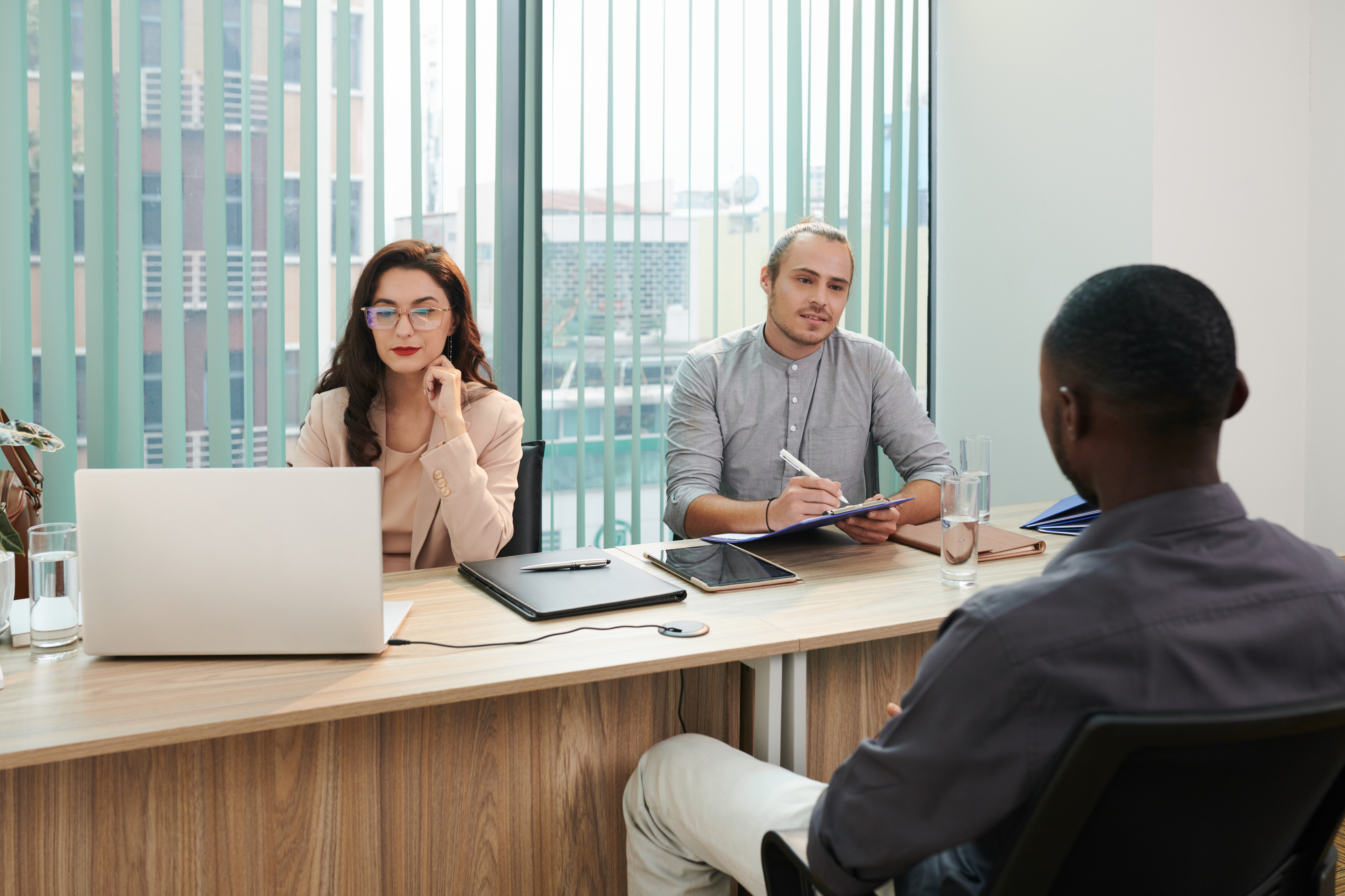 A young male job applicant being interviewed by two hiring managers.