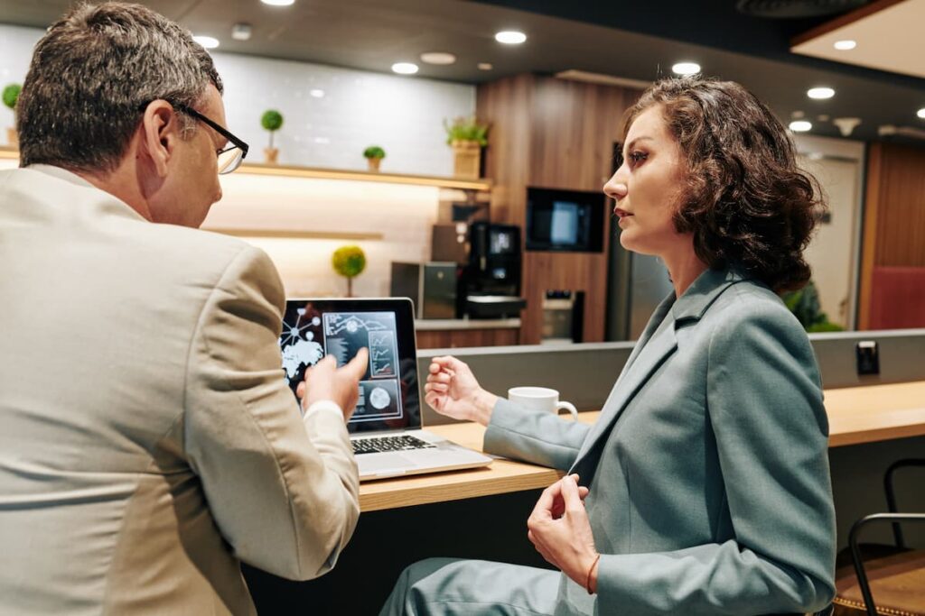 Two business professionals engaged in a meeting in a modern office setting.